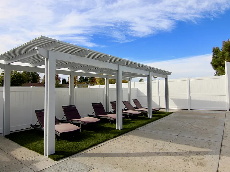 Pool lounging area with gazebo room for at least 5 people.