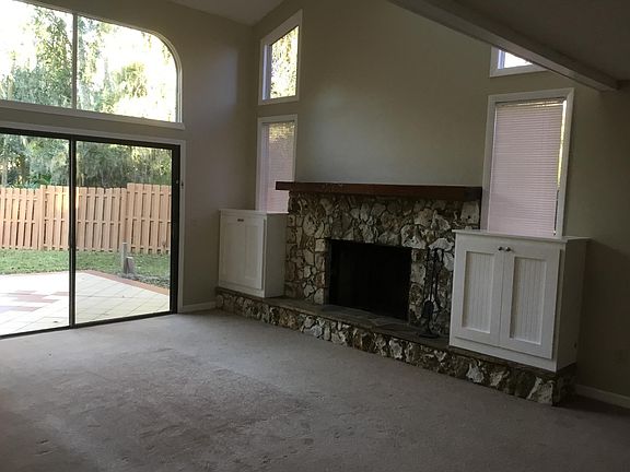 Living rm with fireplace and patio view