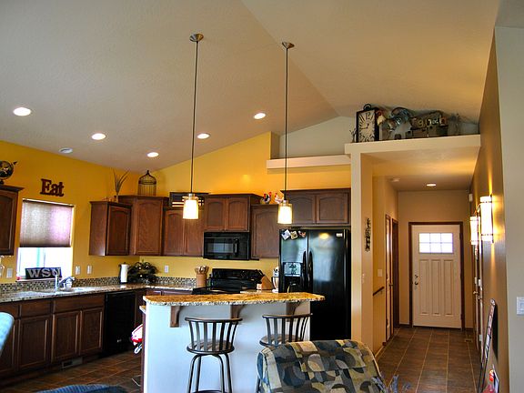 Open kitchen with vaulted ceilings and island with bar top