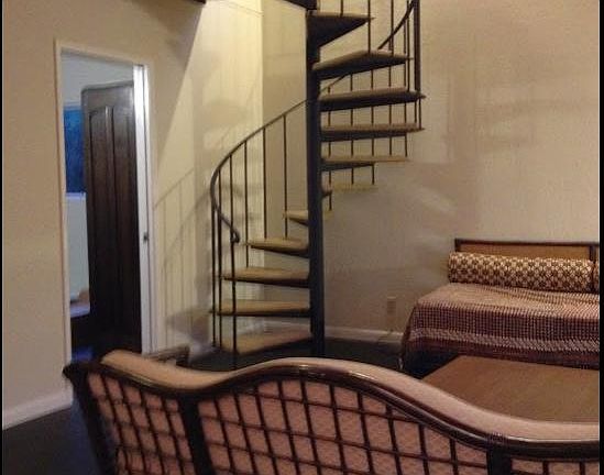 Spiral stairway connects living room to upper bedrooms. The downstairs bedroom/ office is through the door.