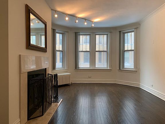 Living Room w/ Track Lighting, Marble Fireplace, and newly varnished Hardwood Floors