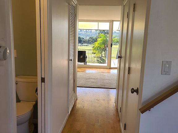 Hallway towards living room with bay view windows.