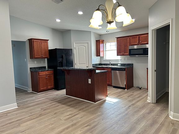 New stove waiting to be installed. Opened door on the right leads to laundry room (washer and dryer not included) then garage.