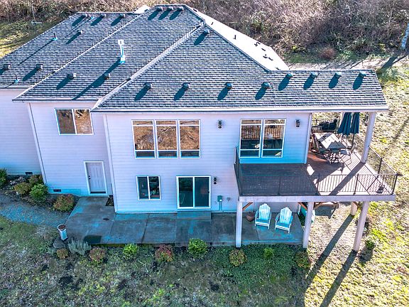 North facing side.Built into a slope which is nice from a wind, sun and noise standpoint. Electric bill is around $100 a month on average. Seriously - that low. Pretty amazing considering propane is only used for stove and fireplace. Well and septic.