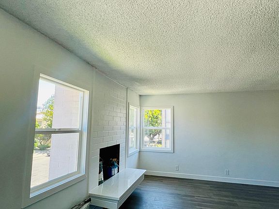 Fireplace in living room with plenty of natural sunlight from the large windows.