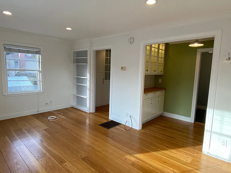 Main room with built in bookcase. Opening on the left leads to closet and bathroom. Opening on right shows dining nook/office and leads to kitchen.