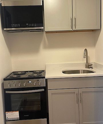 Kitchen with electric stove, refrigerator, microwave