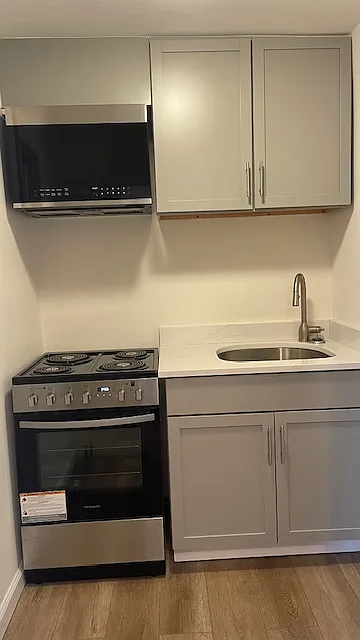 Kitchen with electric stove, refrigerator, microwave