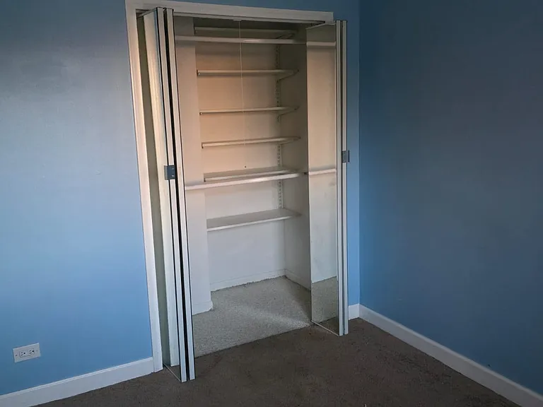 Smaller bedroom with a big closet with mirror doors.