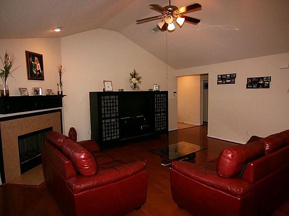Family Room with Gas Fireplace, ceiling fan,  recessed lighting and high ceiling.