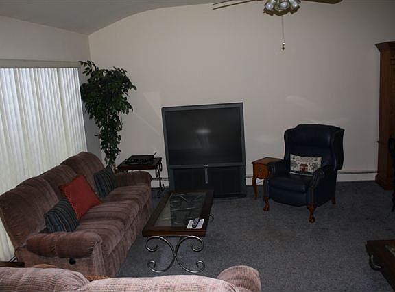 LIVING RM WITH HIGH CEILING,CARPET OVER HARDWOOD,& CEILING FAN