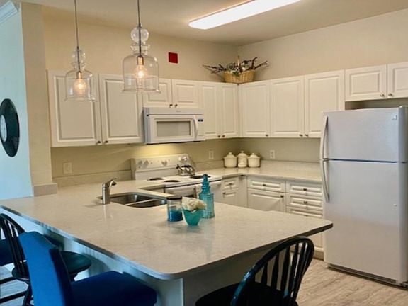 Newly-installed lighting fixtures. New quartz countertops in kitchen and bathroom. Fully-stocked kitchen.