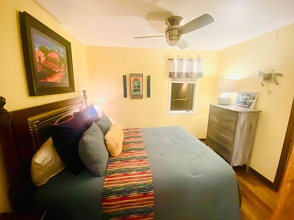 Qn size bedroom. Window opens out to entrance, room darkening shade, ceiling fan.