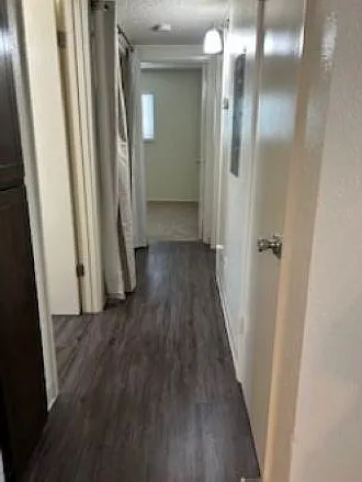 Hallway from living room to bedrooms with guest coat closet, linen closet, and laundry closet