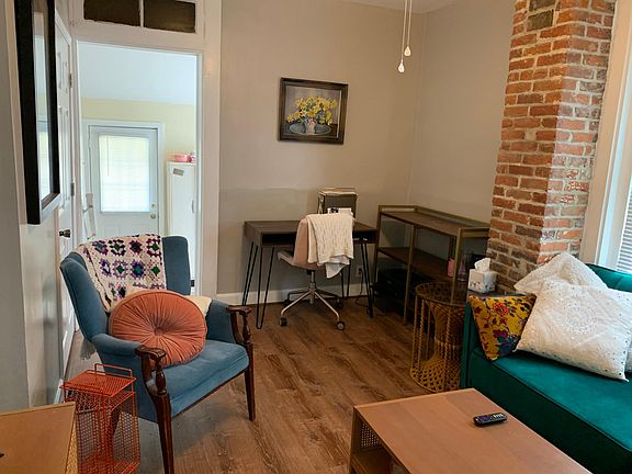 Living room with view into the kitchen and entrance door