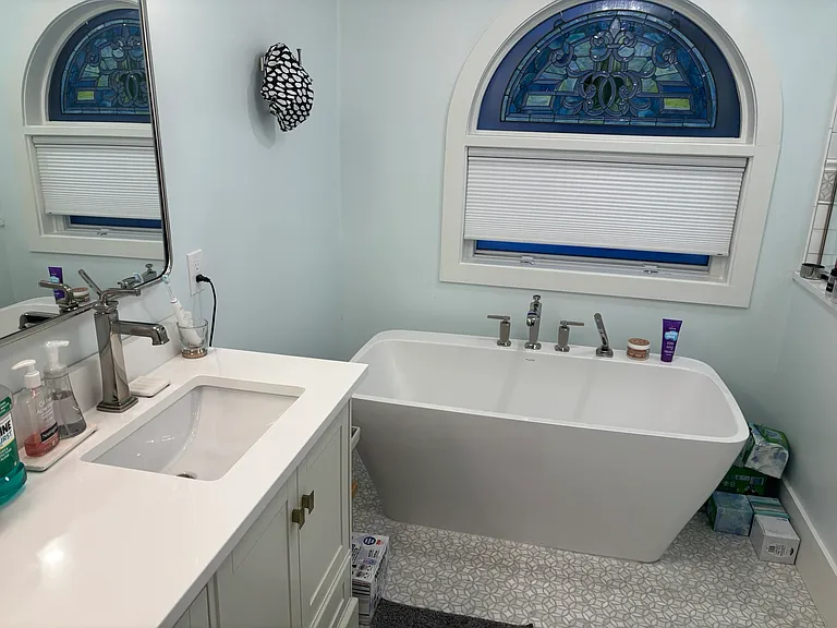Primary bathroom with double sink, roman bathtub, shower and toilet.
