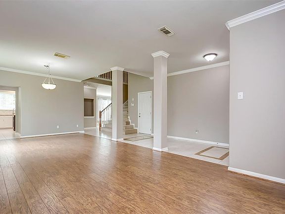 The formal living room has laminate wood floor and crown molding.