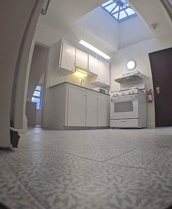 Kitchen view new ceramic floor, large sky window.