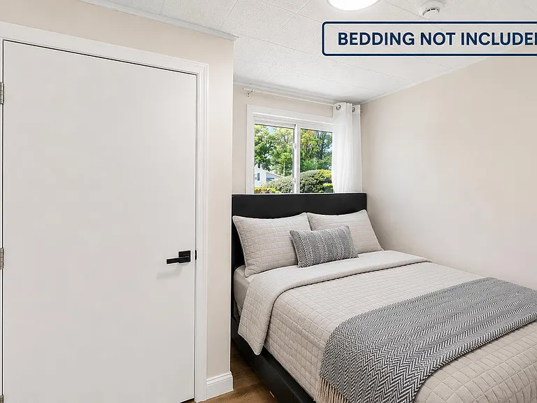 Private bedroom with a bed frame area, window with curtains, and neutral finishes for easy furnishing.