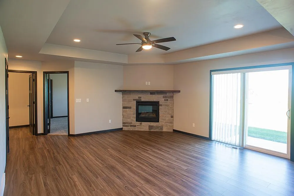 Spacious living room with gas fireplace and patio window to backyard. - 4638 N Cherryvale Ave