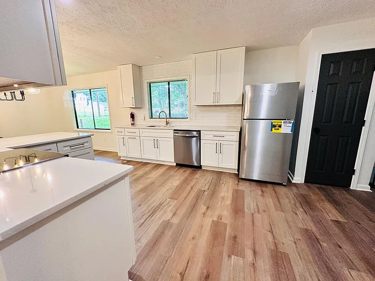 Spacious kitchen with ample cabinet storage, subway-tile backsplash, and stainless-steel appliances plus an island counter.