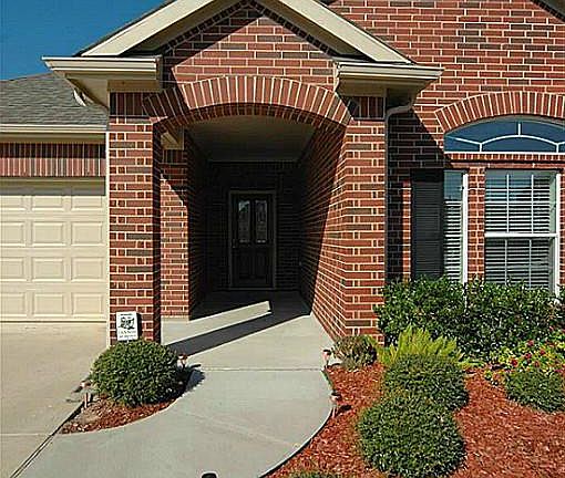 The covered entry lined by attractive landscaping says..."welcome"!