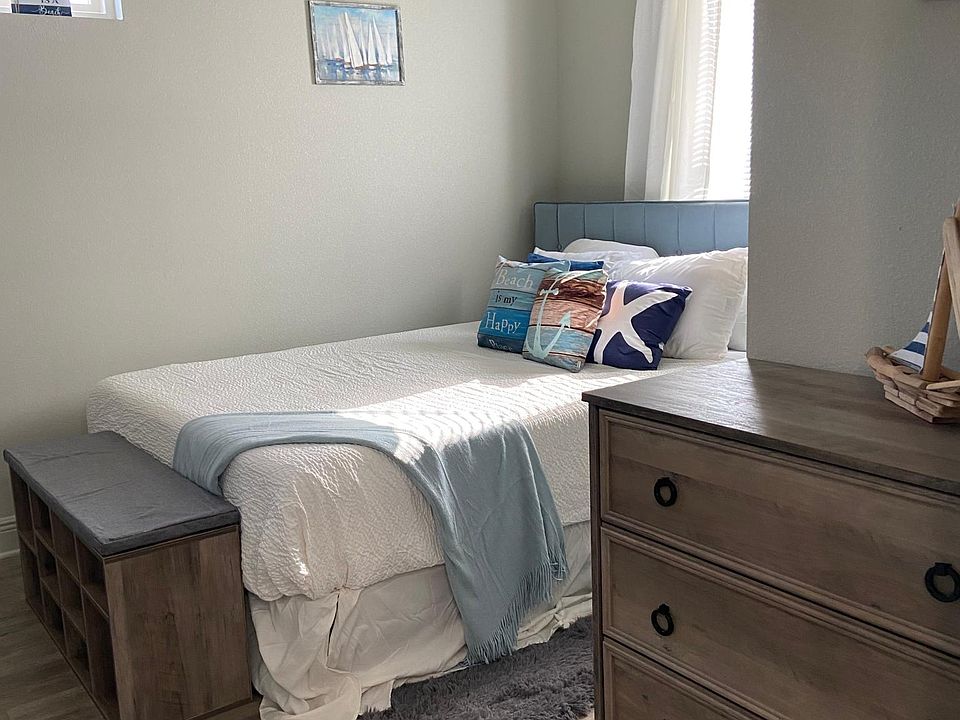 Furnished with dresser, queen sized memory foam bed nightstand, bench, and smart TV.