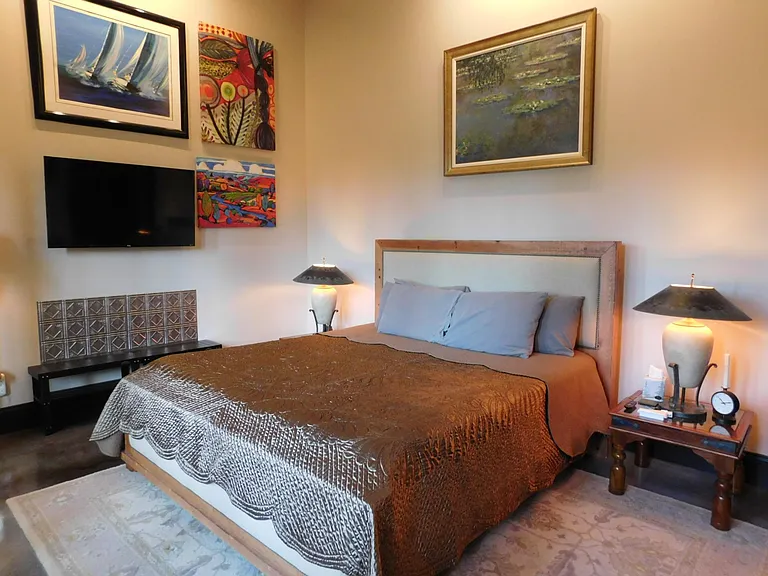 Master bedroom offers King bed, flat screen TV, luggage rack and an abundance of Art