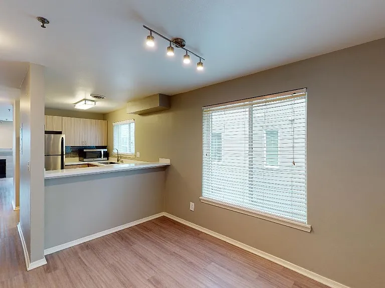 Apartment dining room with wood-style flooring.