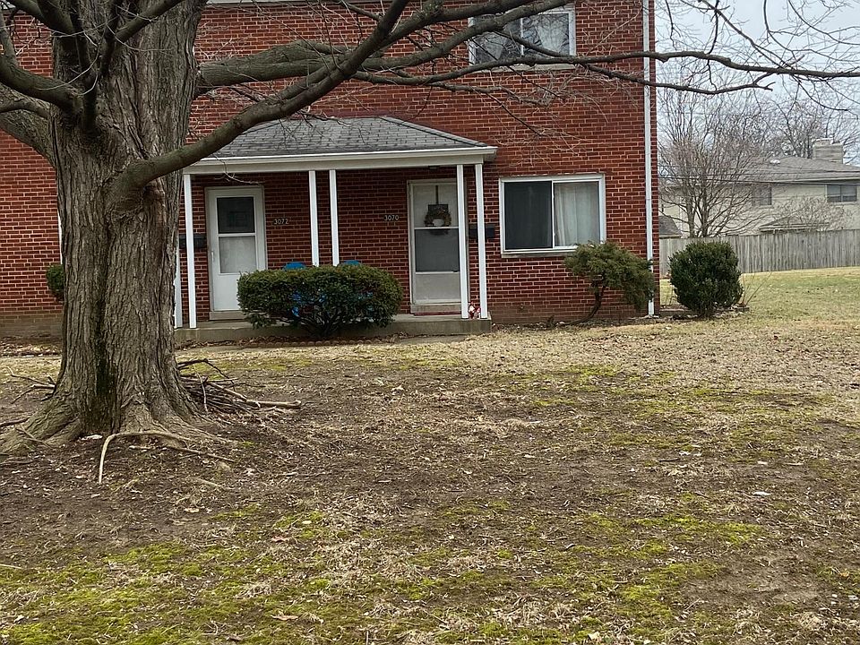 Brick townhouse with mature trees in front yard