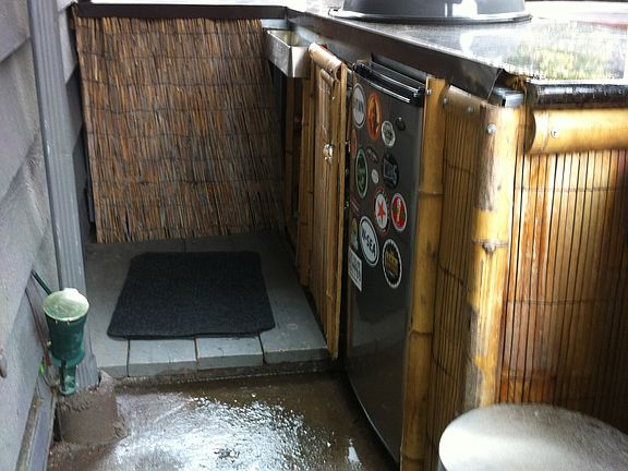 Backyard with small fridge and bbq.