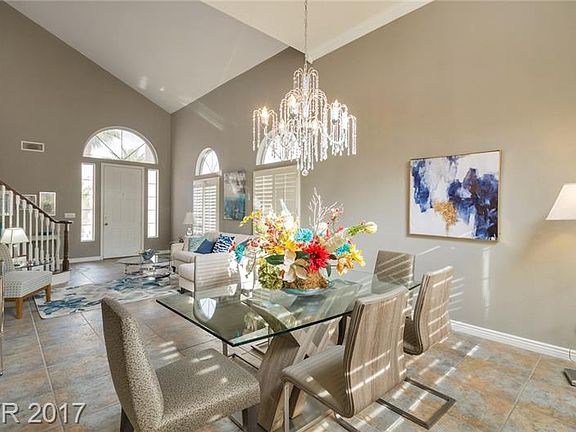Dining room with huge chandelier and tray ceiling.