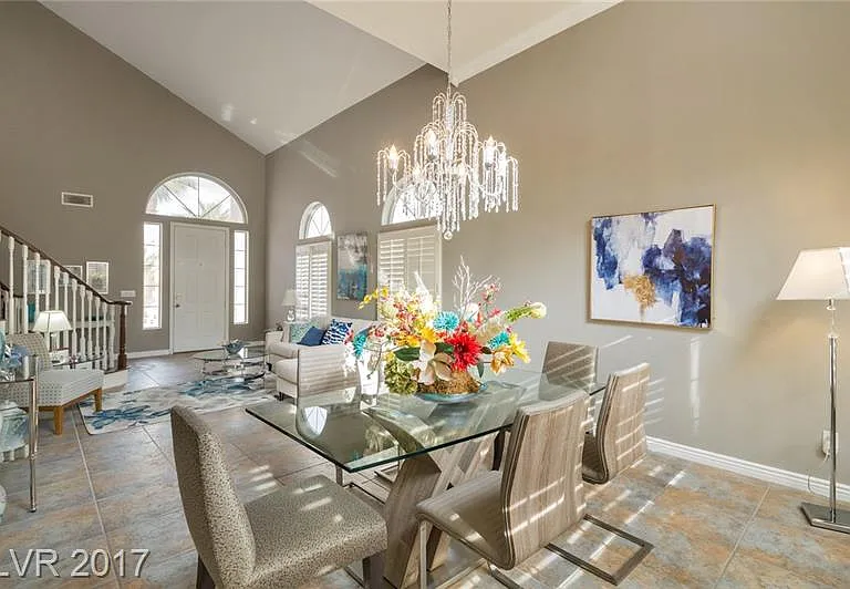 Dining room with huge chandelier and tray ceiling.