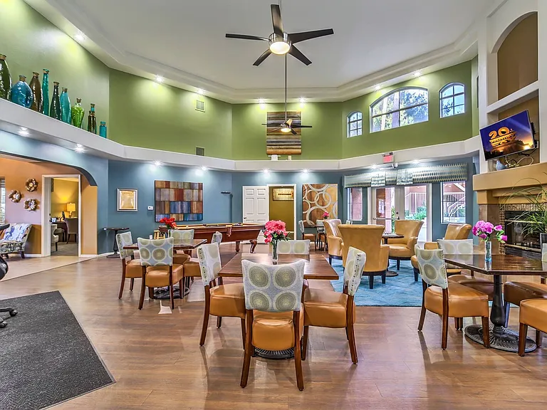 Large resident clubhouse with tables, television, and fireplace.