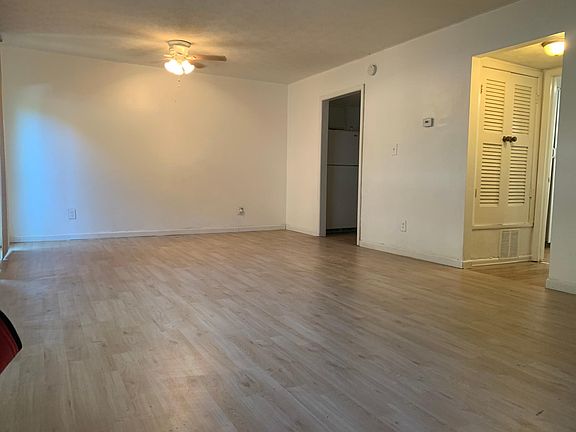 Another view of the living and hallway that leads to downstair bathroom with a small utility closet