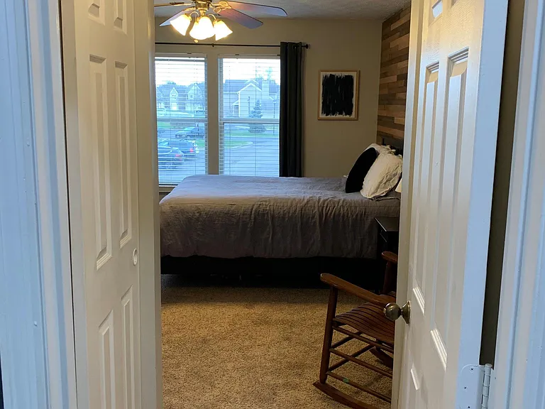 Spacious master bedroom with a gorgeous wood accent wall and ensuite bathroom.