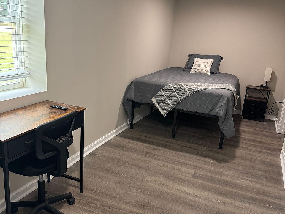 View of bed, desk and nightstand with view of the street