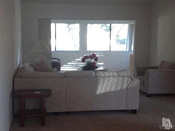 Partial view of the living room looking out through the added extension and family room with enterta