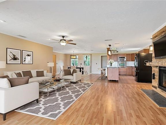 Living room with wood burning fireplace, dining room & kitchen