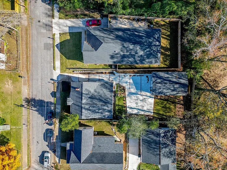 Get a bird's-eye view of your haven! Nestled within a vibrant community, the house reveals its unique layout, with a driveway leading to the back unit and a spacious 60' parking pad. The lush landscaping and inviting outdoor spaces showcase the perfect bl