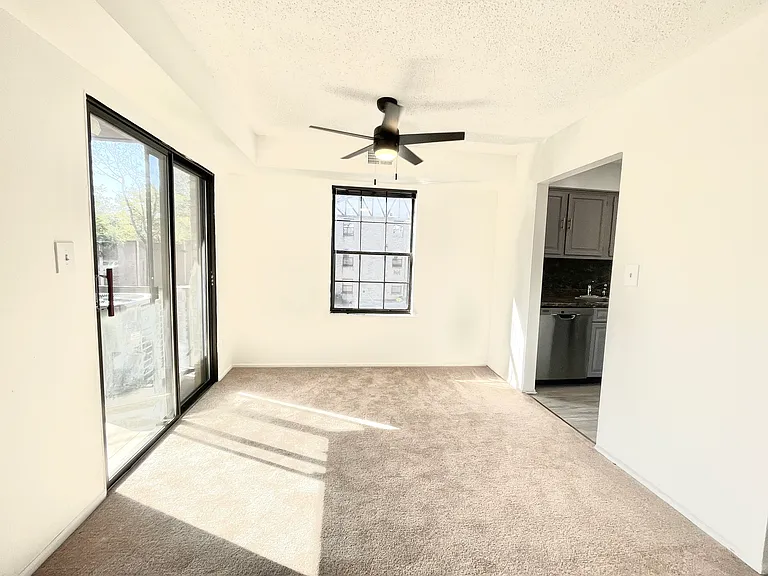 Dining area with private terrace to the left and kitchen to the right - tons of natural light in this corner unit!