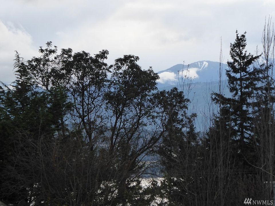 Enhanced photo of the snow dusted Olympic Mountains and partial view of Discovery Bay from the property.