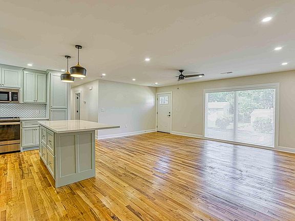 Island with seating. Large window in living room. Blinds provided throughout the house.