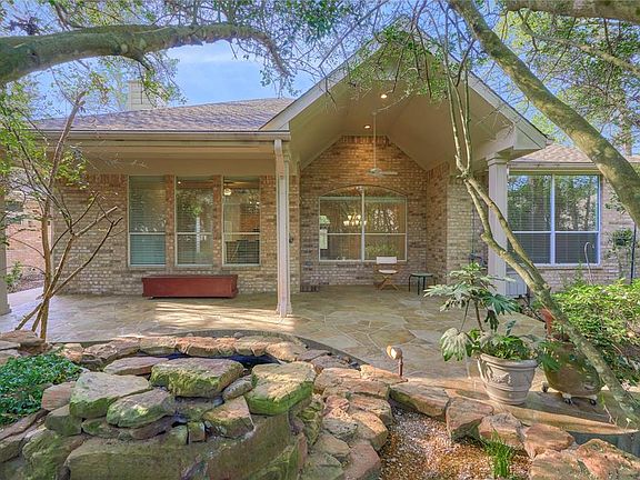 Serene back yard with water feature and extended covered patio.