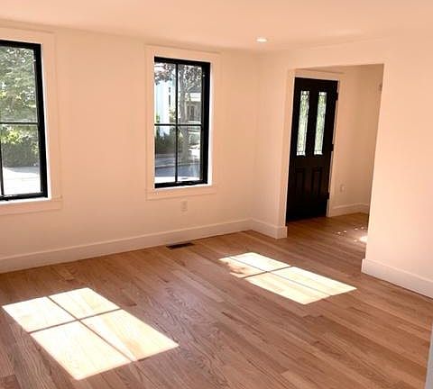Living room looking at front door entrance and foyer with red oak floors.