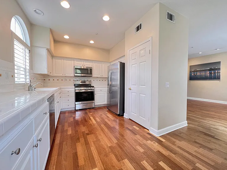 Full stainless steel kitchen with: dishwasher, gas range, microwave, and fridge.