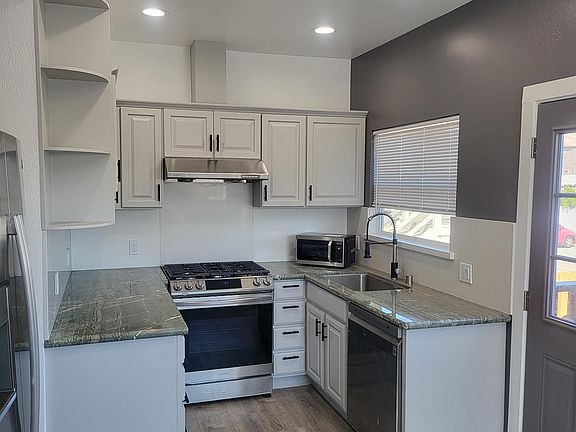 Fully remodeled kitchen with stainless steel appliances, new refrigerator and separate dining area. Back door leads to shared backyard.