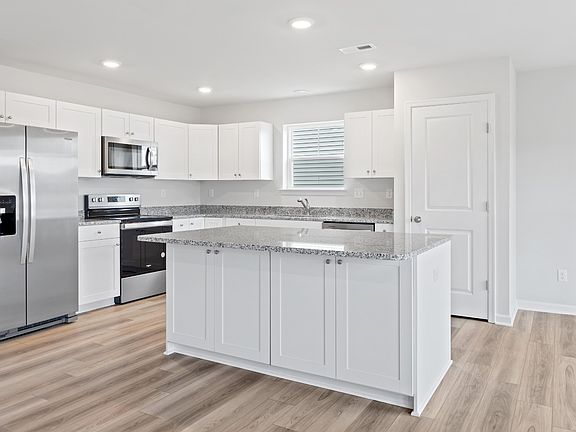 Island kitchen with white cabinets in a DRB Homes Edgewood plan at The Village of College Park commu