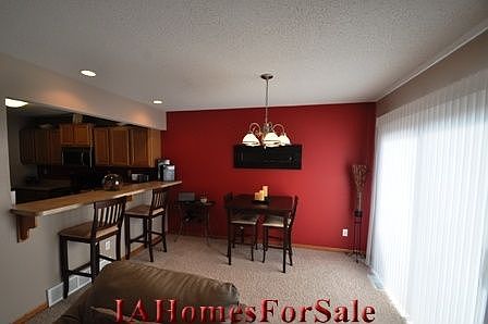 Dining Area, raised bar overlooking kitchen & large area for entertaining guests, also shown is walk-out to upstairs patio/deck!