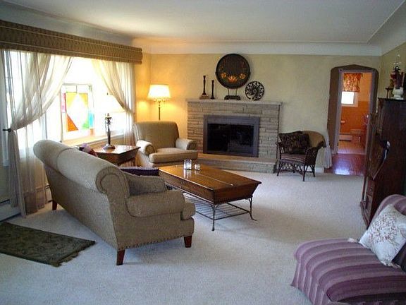 LIving room with chair rail, cove ceiling and wood burning fireplace.
